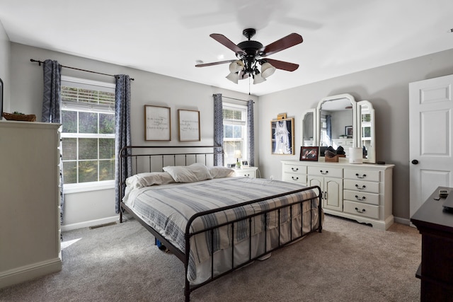 carpeted bedroom with multiple windows and ceiling fan