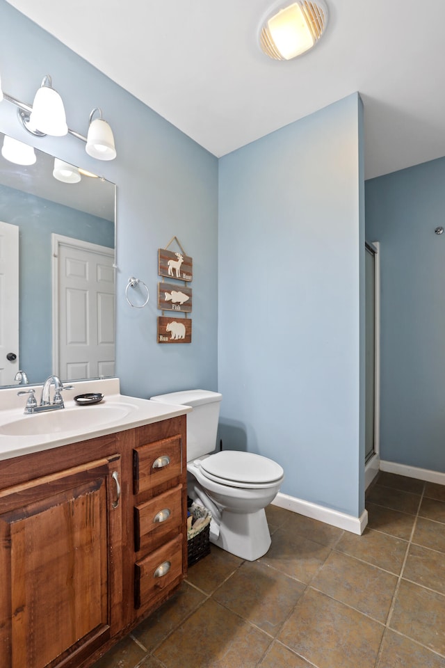 bathroom with tile patterned floors, a shower with door, vanity, and toilet