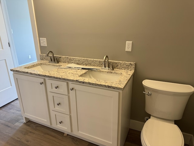 bathroom featuring wood finished floors, a sink, and toilet