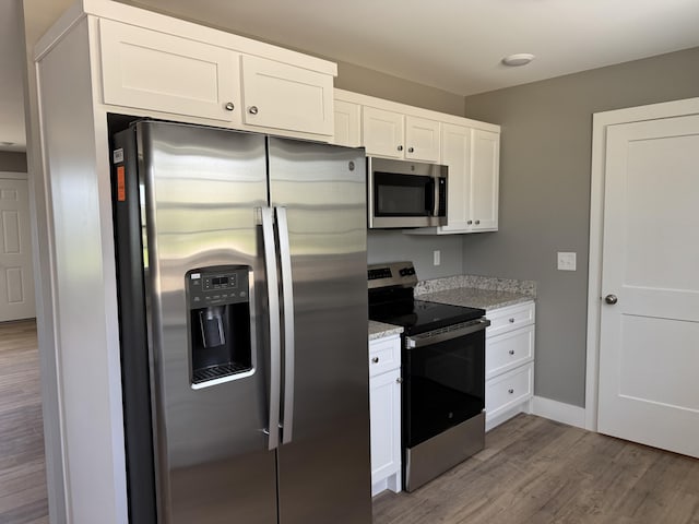 218 Little Acres Rd, Lily, KY 40740 - kitchen with baseboards, light stone counters, white cabinets, appliances with stainless steel finishes, and wood finished floors