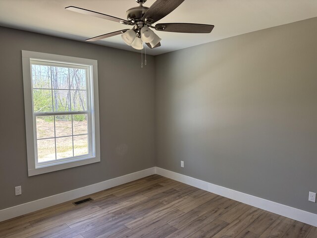 218 Little Acres Rd, Lily, KY 40740 - unfurnished room with wood finished floors, baseboards, a ceiling fan, and a wealth of natural light