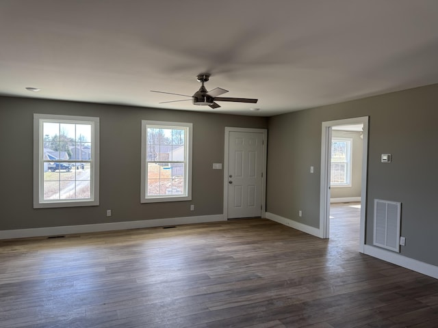 interior space featuring a wealth of natural light, wood finished floors, visible vents, and baseboards