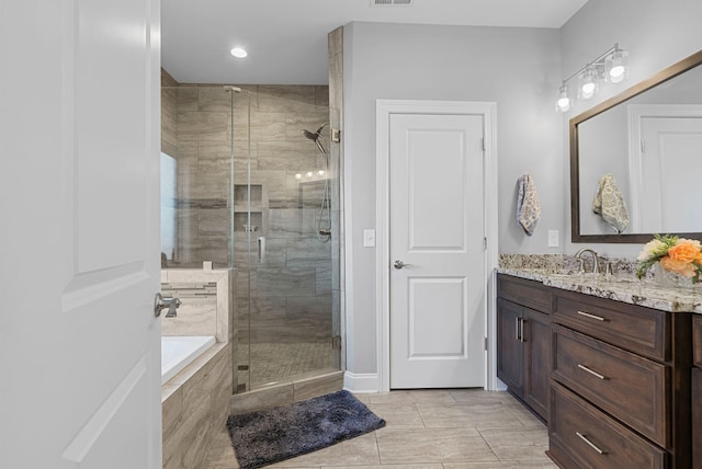 bathroom with tile patterned flooring, separate shower and tub, and vanity