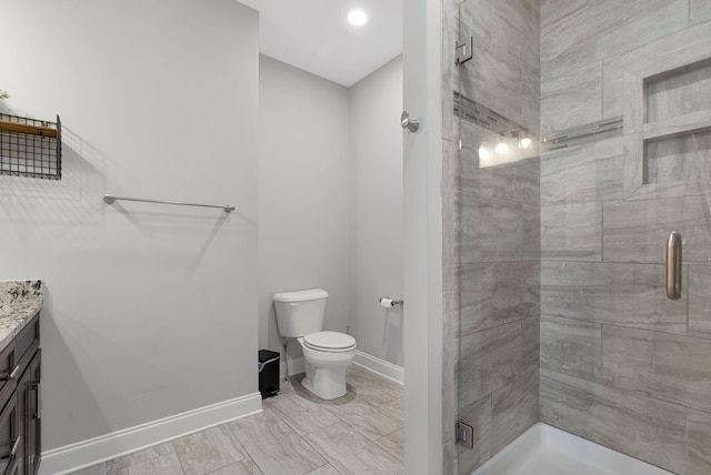 bathroom with vanity, toilet, and a shower with door