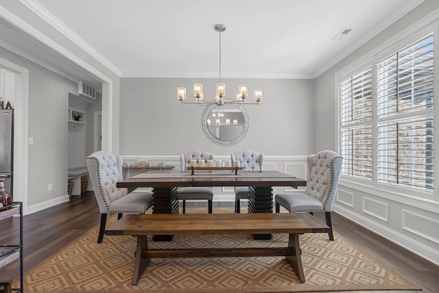 dining room with an inviting chandelier, dark hardwood / wood-style floors, and ornamental molding