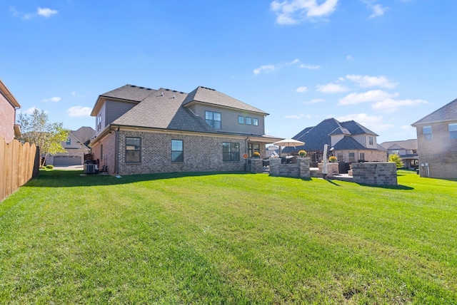 rear view of property featuring cooling unit and a yard