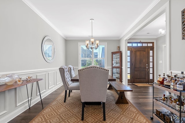 dining area featuring a chandelier, dark hardwood / wood-style flooring, and crown molding