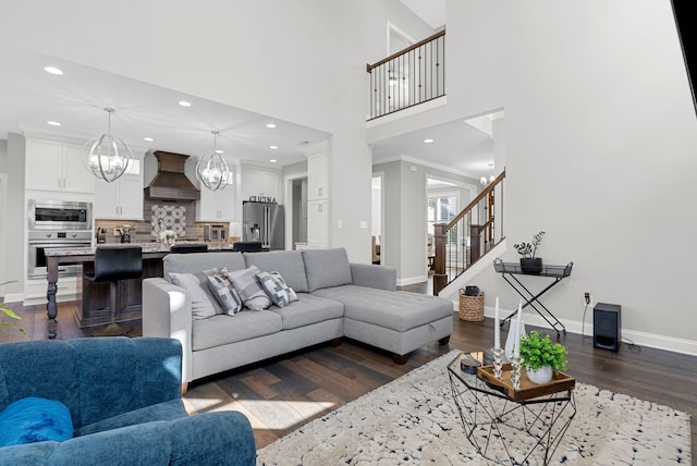 living room featuring crown molding, a towering ceiling, and dark hardwood / wood-style floors