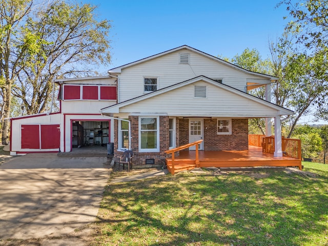 view of front facade with a front yard, a garage, a deck, and an outbuilding