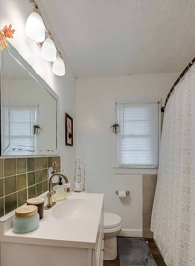 bathroom with decorative backsplash, hardwood / wood-style floors, vanity, and toilet