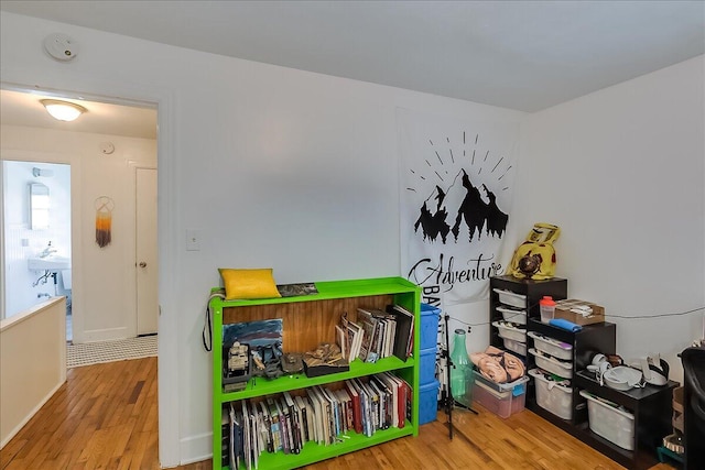 game room with sink and light wood-type flooring