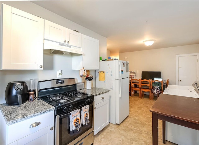 kitchen featuring white fridge, light stone countertops, stainless steel gas range, and white cabinets