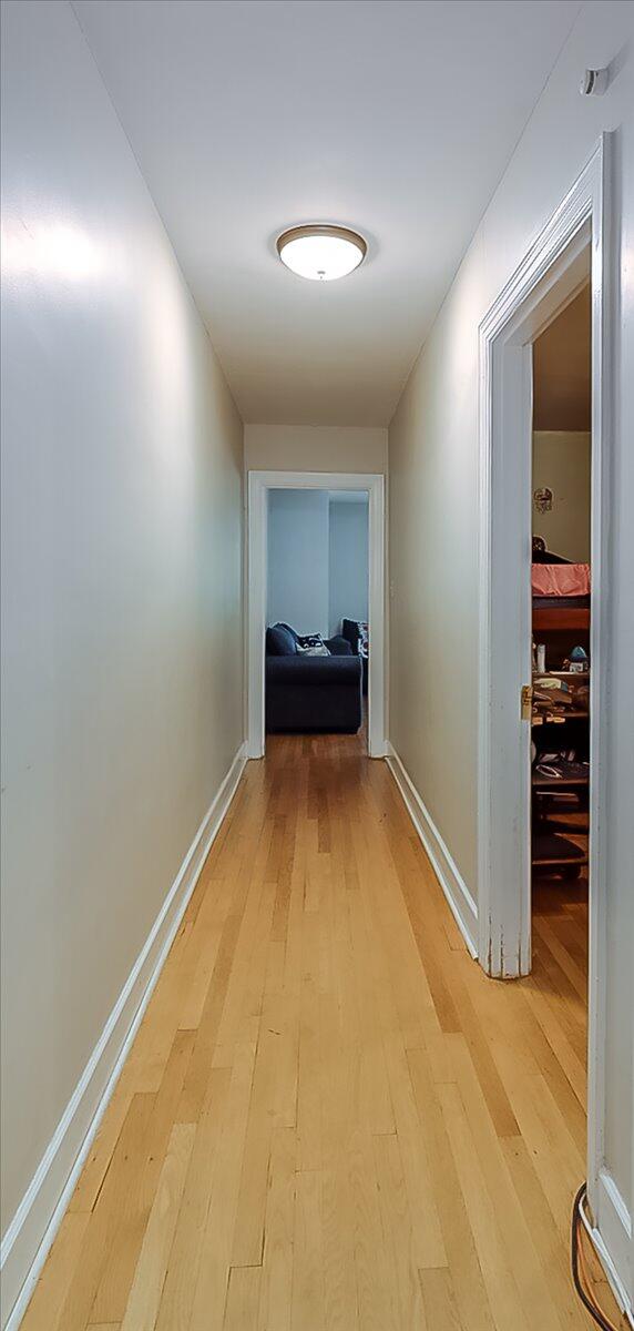 corridor with light hardwood / wood-style floors