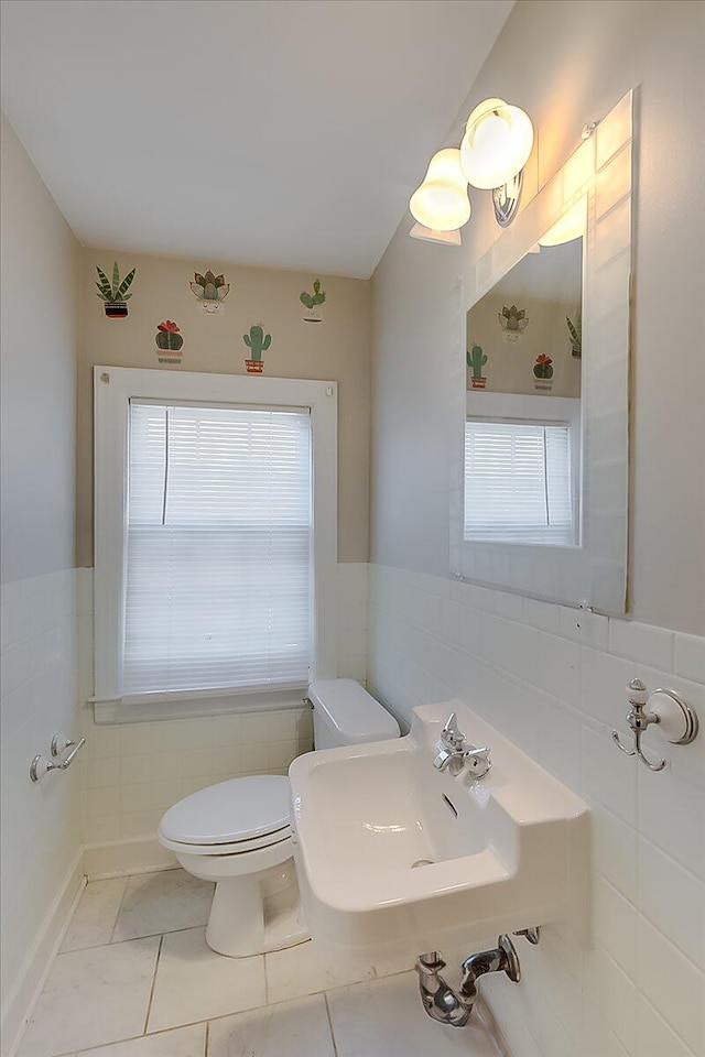 bathroom with sink, plenty of natural light, toilet, and tile patterned flooring