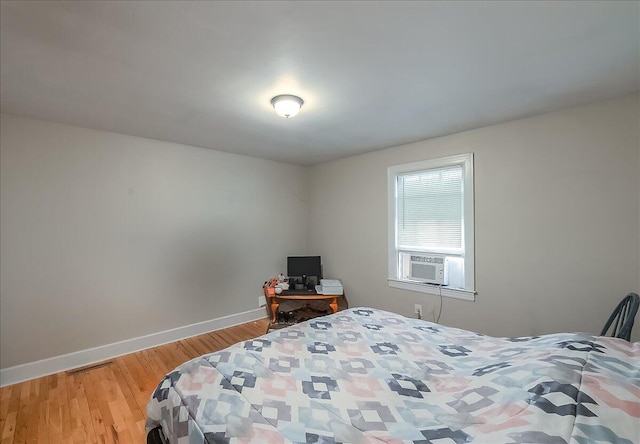 bedroom with hardwood / wood-style flooring and cooling unit