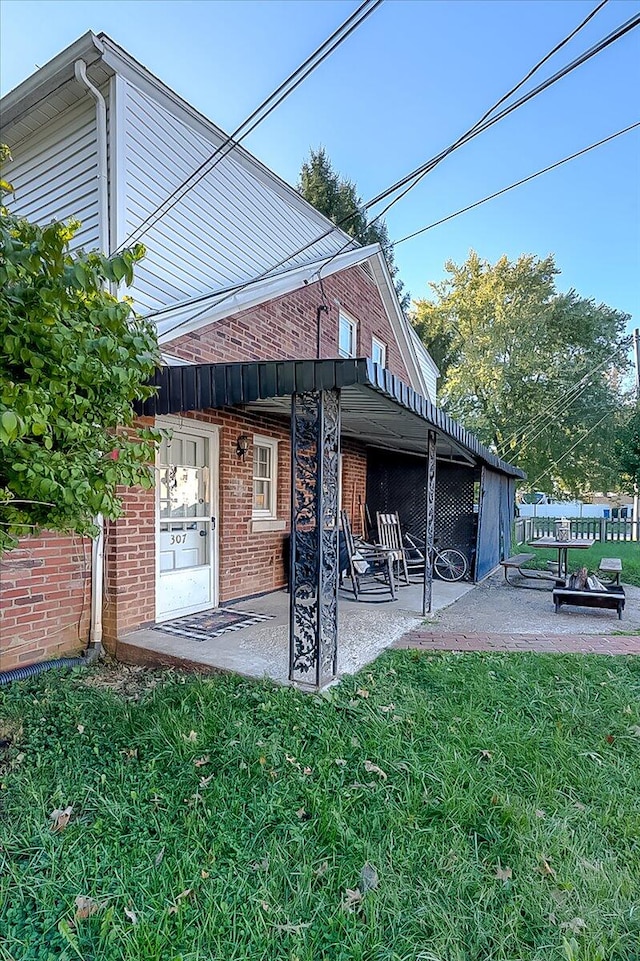 back of house with a lawn and a patio