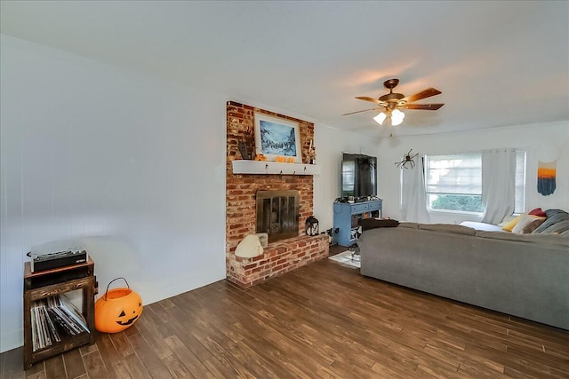 living room with a fireplace, ceiling fan, and dark hardwood / wood-style flooring