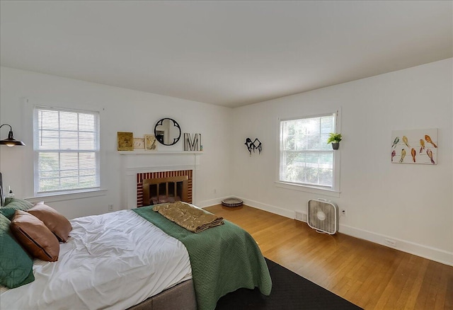 bedroom featuring a fireplace and wood-type flooring