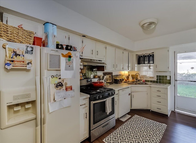 kitchen with tasteful backsplash, white appliances, dark wood-type flooring, sink, and white cabinetry