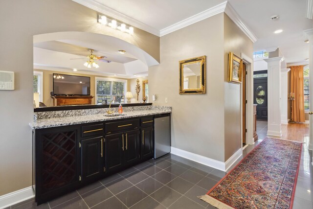 bar with a ceiling fan, ornamental molding, dishwasher, a sink, and baseboards