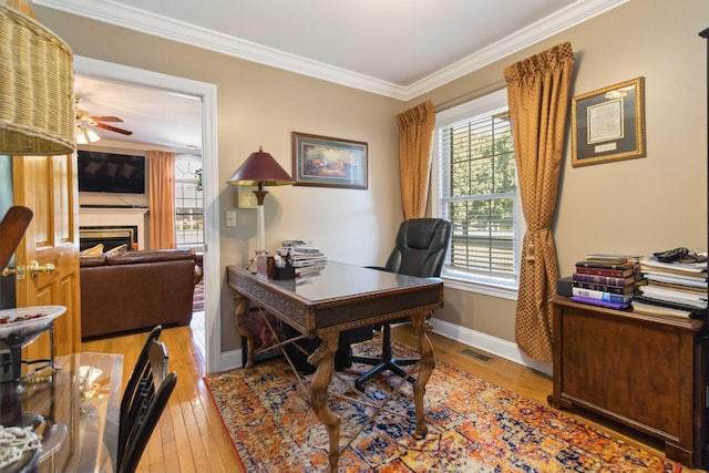 office area featuring a wealth of natural light, hardwood / wood-style floors, visible vents, and crown molding