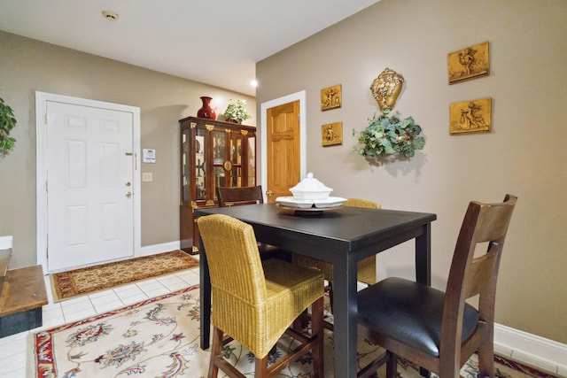 dining space featuring baseboards and light tile patterned flooring