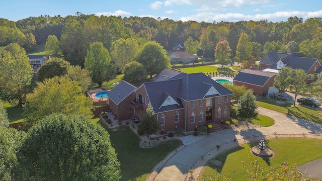 drone / aerial view featuring a wooded view