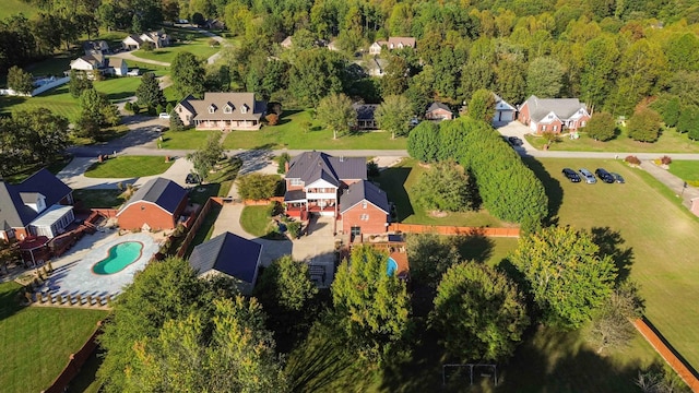 drone / aerial view featuring a residential view and a view of trees