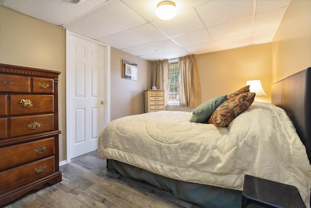 bedroom featuring dark wood-style flooring and a drop ceiling