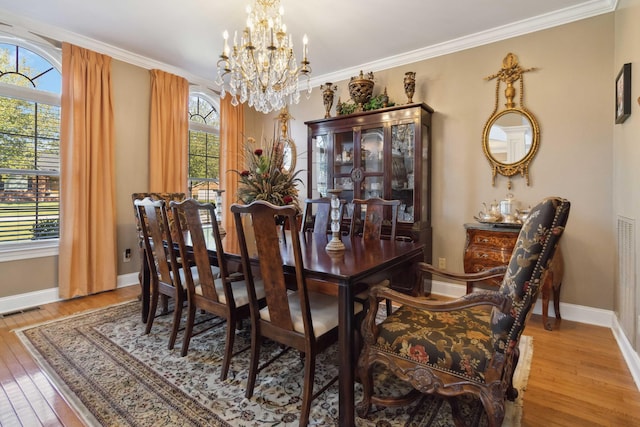 dining area featuring visible vents, baseboards, a notable chandelier, hardwood / wood-style flooring, and crown molding