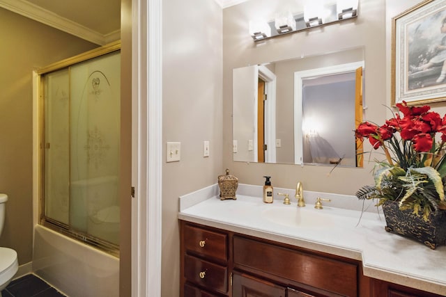 full bath with vanity, ornamental molding, toilet, combined bath / shower with glass door, and tile patterned floors