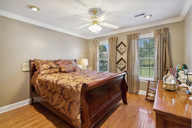 bedroom with crown molding, light wood finished floors, baseboards, and visible vents