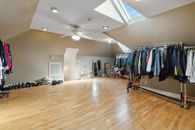 spacious closet featuring visible vents, ceiling fan, wood finished floors, and lofted ceiling with skylight