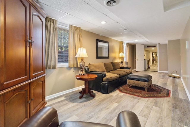 living area with light wood-type flooring, a drop ceiling, visible vents, recessed lighting, and baseboards