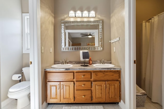 bathroom featuring a sink, tile patterned floors, toilet, and double vanity
