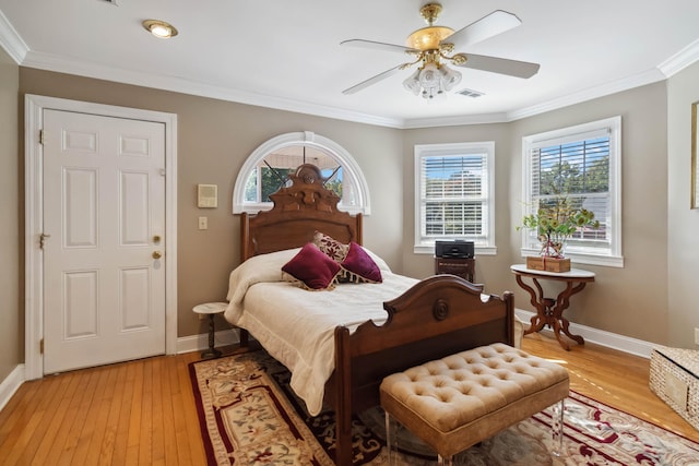 bedroom featuring light wood-type flooring, baseboards, ornamental molding, and visible vents