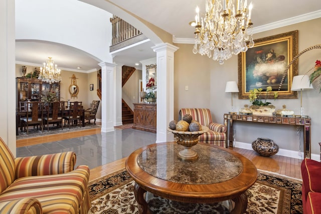 living area featuring a notable chandelier, baseboards, crown molding, decorative columns, and arched walkways