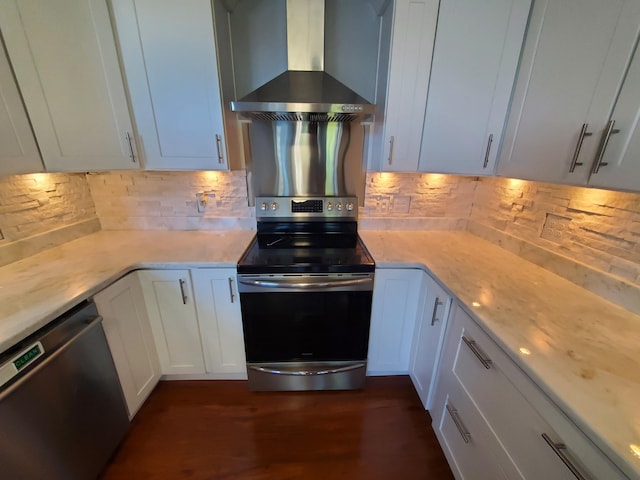 kitchen featuring white cabinets, backsplash, dark wood-type flooring, wall chimney range hood, and stainless steel appliances