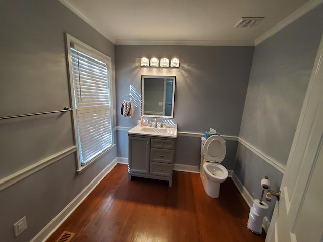 bathroom with crown molding, hardwood / wood-style floors, vanity, and toilet