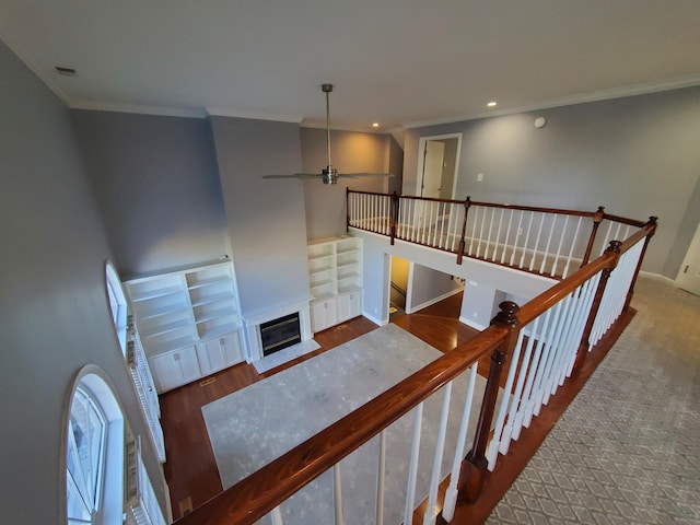 stairway with ornamental molding, hardwood / wood-style floors, and ceiling fan