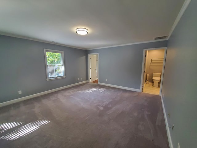 unfurnished bedroom featuring ornamental molding, ensuite bath, and carpet flooring