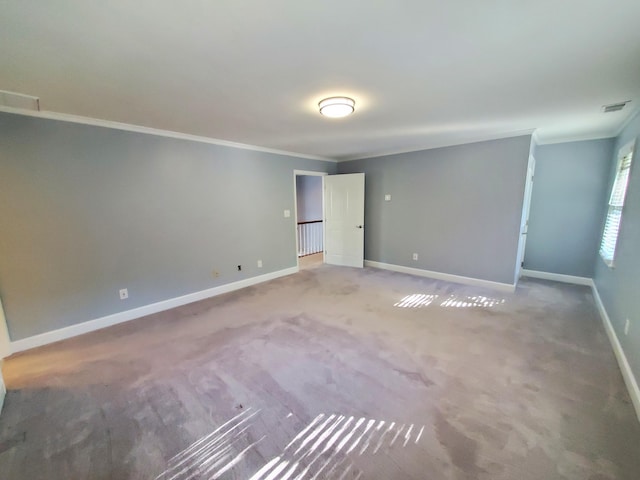 empty room with ornamental molding and carpet flooring