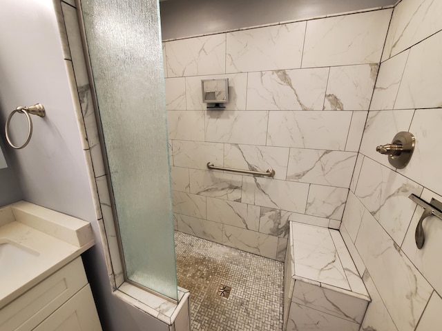 bathroom featuring tiled shower and vanity