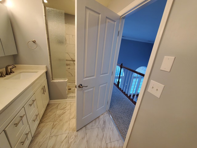 bathroom with a tile shower and vanity