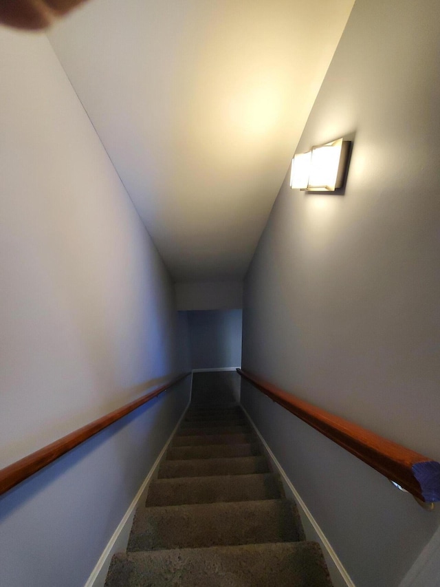 stairs featuring lofted ceiling and carpet floors