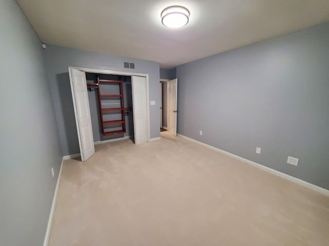 unfurnished bedroom featuring a closet and light colored carpet