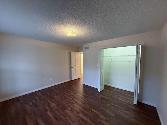 unfurnished bedroom with visible vents, baseboards, a closet, and dark wood-style flooring