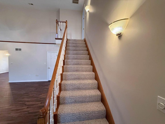 stairs with visible vents, baseboards, and wood finished floors