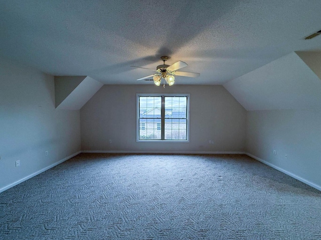 bonus room featuring baseboards, a textured ceiling, carpet flooring, and vaulted ceiling