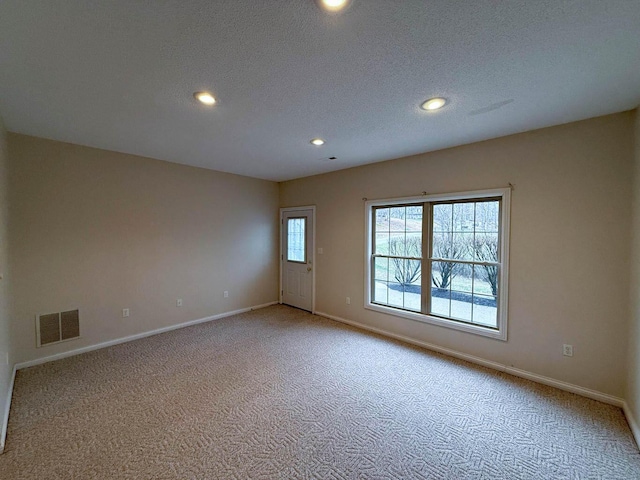 empty room with visible vents, baseboards, light colored carpet, recessed lighting, and a textured ceiling